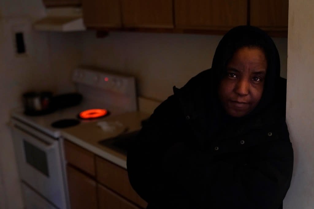 Genevieve Tyler stands for a portrait where she uses the stove’s electric burner to heat the apartment she is living in Monday, Jan. 8, 2024, in Harvey, Ill. (AP Photo/Charles Rex Arbogast)