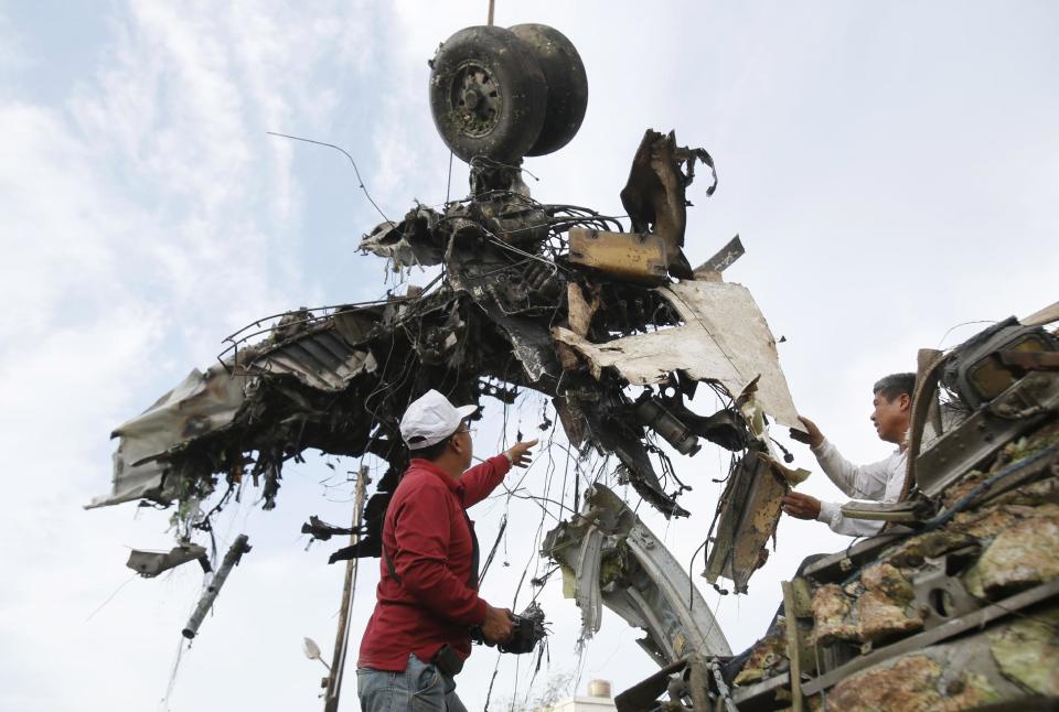 Emergency workers remove the wreckage of crashed TransAsia Airways flight GE222 on the outlying island of Penghu, Taiwan, Thursday, July 24, 2014. Stormy weather on the trailing edge of Typhoon Matmo was the likely cause of the plane crash that killed more than 40 people, the airline said Thursday. (AP Photo/Wally Santana)