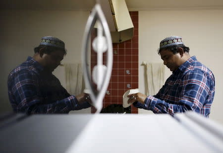 Abu Said Shekh, a 46-year-old asylum seeker from Bangladesh, washes dishes at his house in Sakaimachi near Ota, Gunma prefecture, north of Tokyo, Japan, in this April 5, 2015 file photo. He was among 22 illegal immigrants, including an undisclosed number of asylum seekers, that were put on a state-chartered plane and flown back to Bangladesh on November 25, 2015, Japan's Justice Ministry said. REUTERS/Yuya Shino/Files