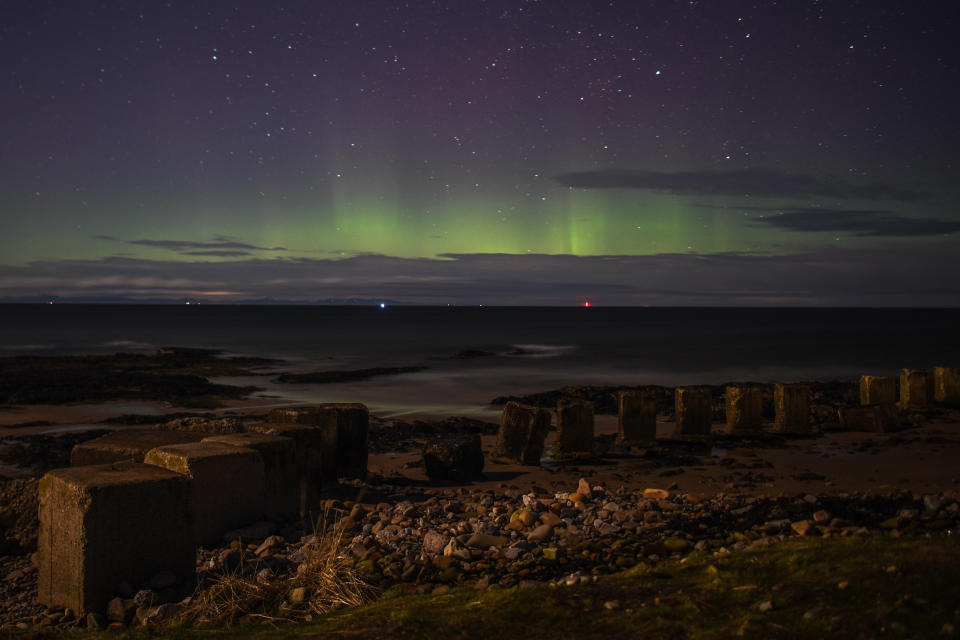 LOSSIEMOUTH, SCOTLAND - FEBRUARY 20: The Aurora Borealis is seen above WW2 beach defenses on February 20, 2021 in Lossiemouth, Scotland. The Aurora Borealis, more commonly known as the Northern Lights, occurs when solar winds drive charged particles from the sun which strike atoms and molecules in Earths atmosphere causing the light show. (Photo by Peter Summers/Getty Images)