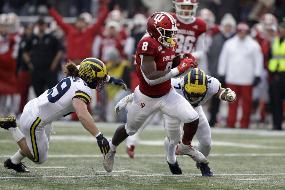 Indiana running back Stevie Scott III (8) is tackled by Michigan's Jordan Glasgow (29) and linebacker Khaleke Hudson (7) during the first half of an NCAA college football game, Saturday, Nov. 23, 2019, in Bloomington, Ind. (AP Photo/Darron Cummings)