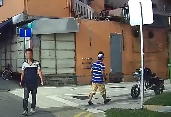 The peddler (left) at his spot in Lorong 6 Geylang. (Yahoo Singapore photo: Safhras Khan)