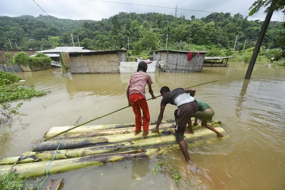 Villager uses banana tree raft to move across a flooded locality in Kamrup district of Assam, in India on 14 July 2020. (Photo by David Talukdar/NurPhoto via Getty Images)