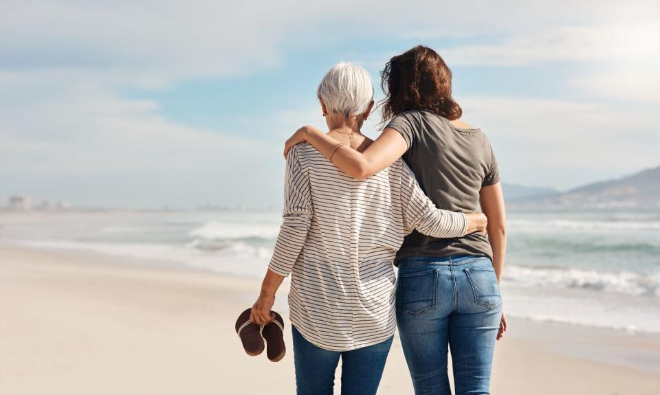 mother and daughter embracing on beach walk