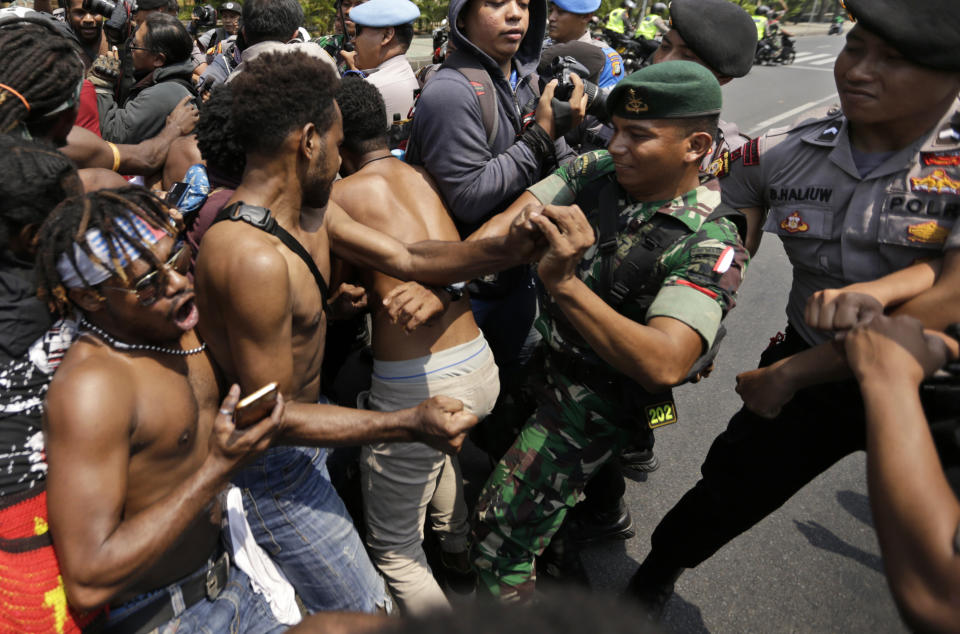 Papuan activists scuffle with police and soldiers during a rally near the presidential palace in Jakarta, Indonesia, Thursday, Aug. 22, 2019. A group of West Papuan students in Indonesia's capital staged the protest against racism and called for independence for their region. (AP Photo/Dita Alangkara)