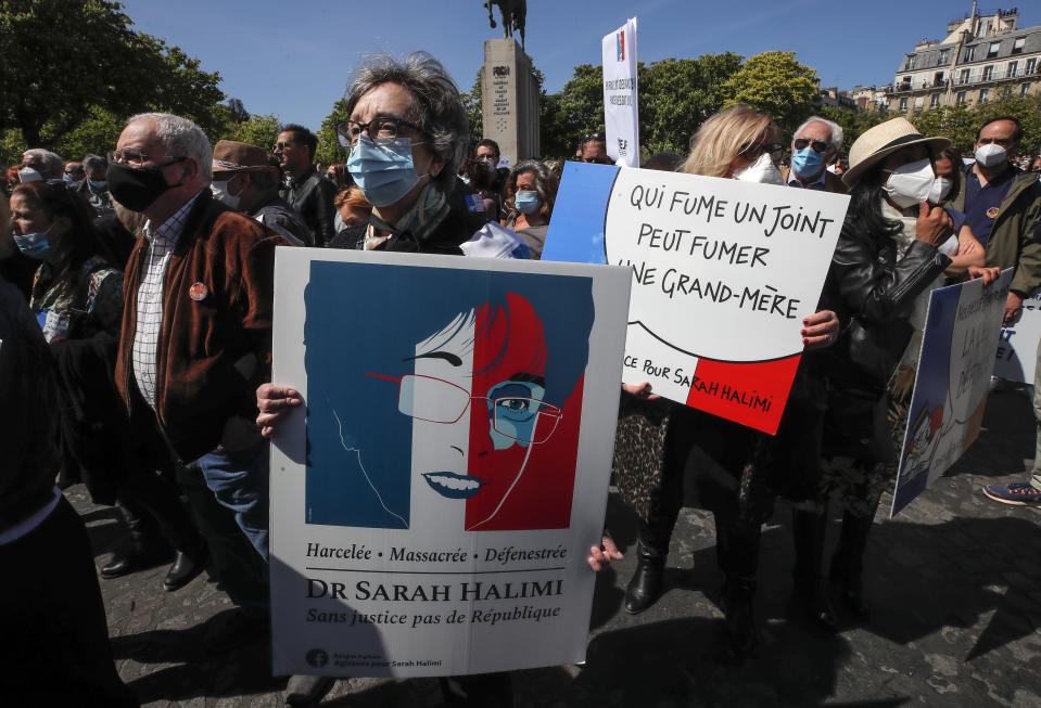 A woman holds a placard depicting Sarah Halimi reading, "harassed, killed, defenestrated without justice no republic," during a protest organized by Jewish associations, who say justice has not been done for the killing of French Jewish woman Sarah Halimi, at Trocadero Plaza near Eiffel Tower in Paris, Sunday, April 25, 2021. Thousands of people have gathered in Paris and other French cities to denounce a ruling by France's highest court that the killer of Jewish woman Sarah Halimi was not criminally responsible and therefore could not go on trial. (AP Photo/Michel Euler)