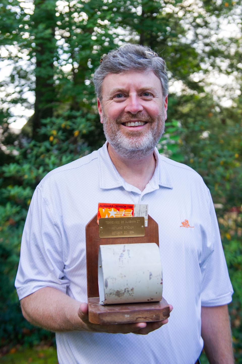 Ned Vickers poses with a piece of the field goal post from the Oct. 20, 1984 Tennessee football game against Alabama on Tuesday, Oct. 10, 2023.