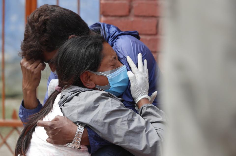 Two people hug at a funeral