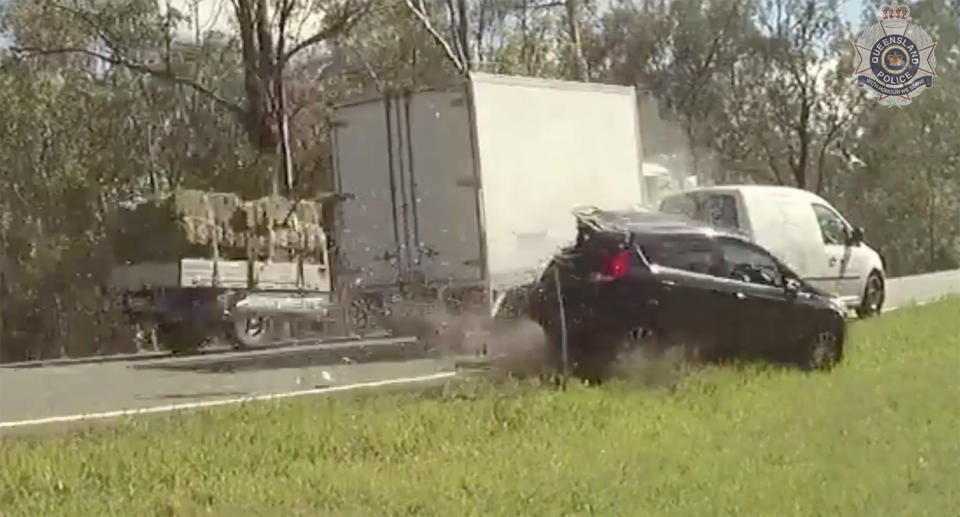 A poloice body cam captured the moment the distracted truck driver smashes into the black parked car. Image: Queensland Police