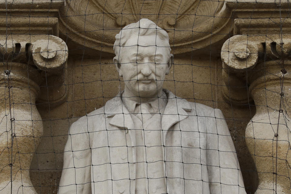 A statue of Cecil Rhodes, the controversial Victorian imperialist who supported apartheid-style measures in southern Africa stands mounted on the facade of Oriel College in Oxford, England, Wednesday, June 17, 2020. The governing body of Oriel College are meeting today to discuss the future of the statue. (AP Photo/Matt Dunham)