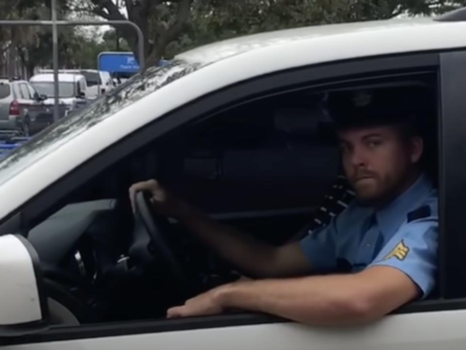A screenshot of a YouTube video showing Charles Ross dressed in a police uniform.