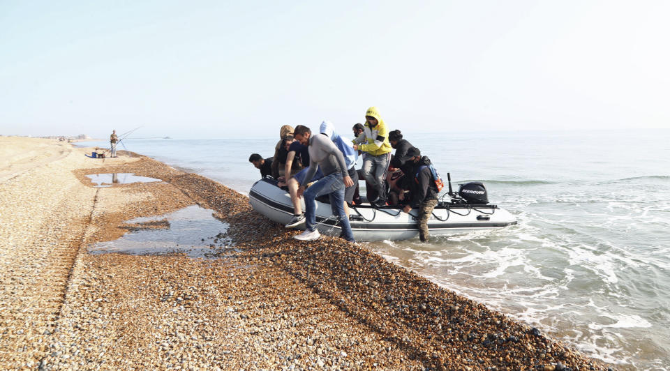 A group of people thought to be migrants arrive in an inflatable boat at Kingsdown beach after crossing the English Channel, near Dover, Kent, England, Monday, Sept. 14, 2020. (Gareth Fuller/PA via AP)