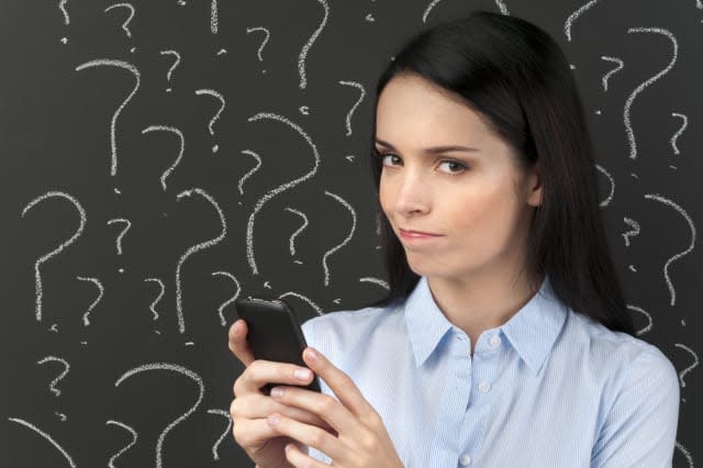 Mobile phone service concept - Woman texting with question marks on a blackboard.