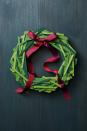 <p>Stock up on small and large craft sticks, then have the kids paint them three different shades of green. Glue the sticks to a 12" foam wreath, overlapping and mixing the shades of green as you go. A red ribbon finishes off the look.</p>