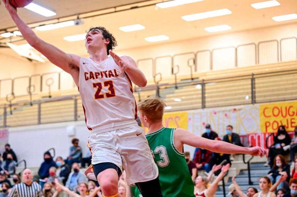 Capital forward Wesley Bjornsgard (23) goes in for a layup past Tumwater forward Tanner Brewer (33) in the final seconds of the fourth quarter of a non-league game in Olympia on Saturday, Jan. 22, 2022.