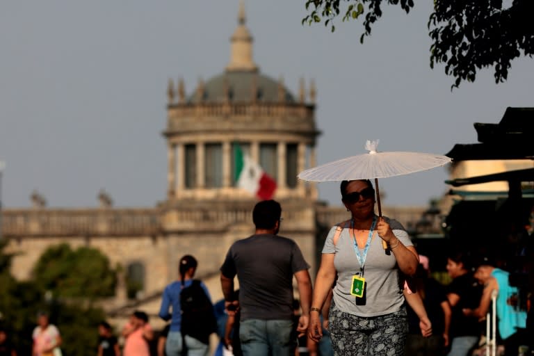 People protect themselves from the sun during a heat wave hitting the country, in Guadalajara, Jalisco state, Mexico, in May 2024 (ULISES RUIZ)