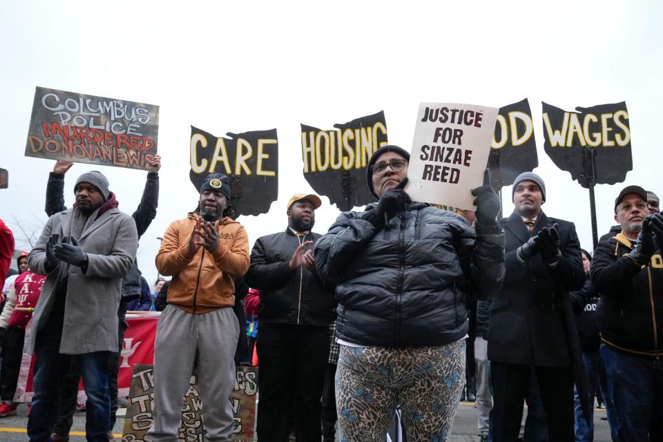 Kathy Burgess holds a “Justice for Sinzae Reed” sign during the city's Martin Luther King Jr. march outside of the Lincoln Theatre Monday.