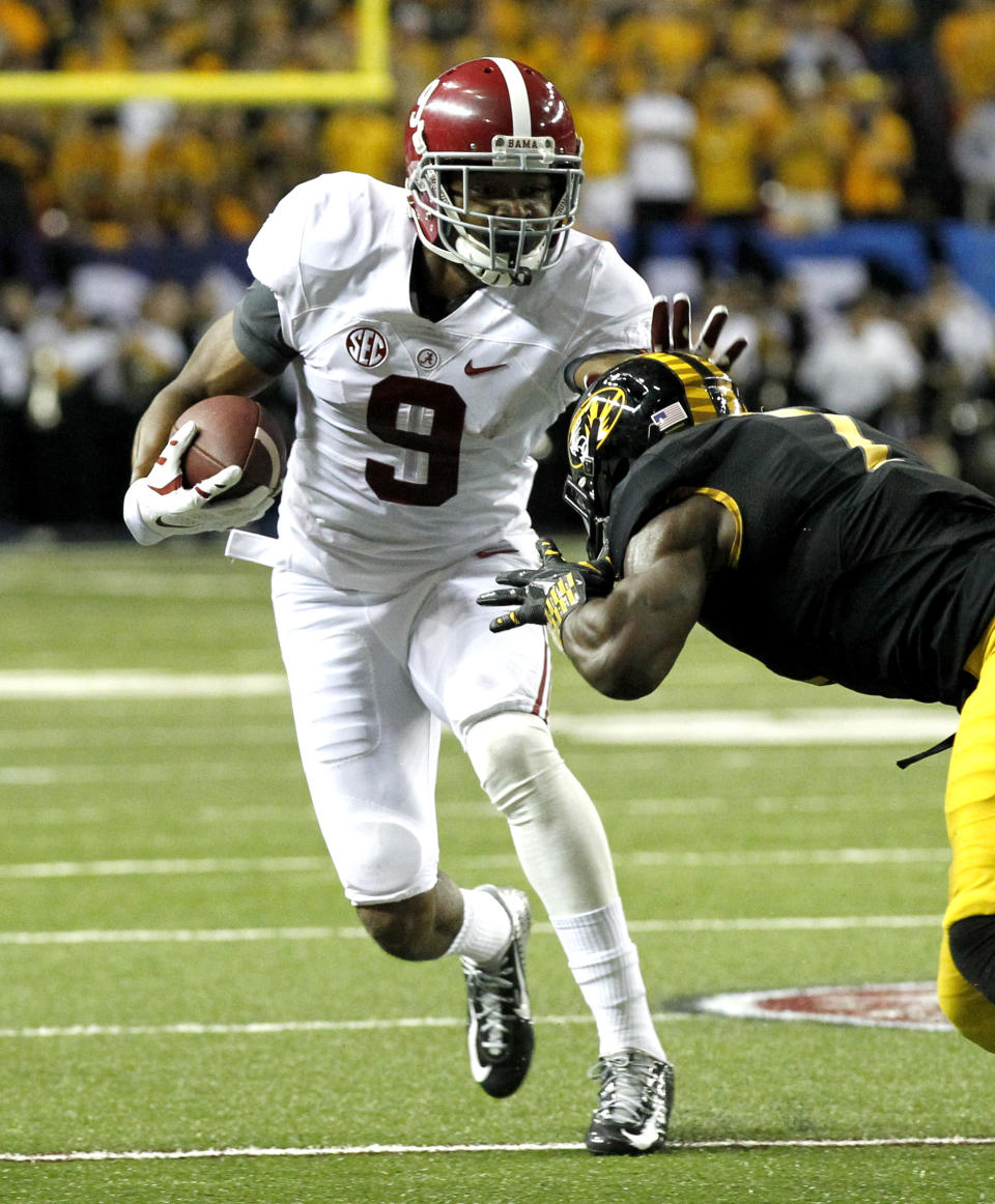 Alabama wide receiver Amari Cooper (9) stiff arms Missouri defensive back Kenya Dennis during the first half of an NCAA college football game Saturday, Dec. 6, 2014, in Atlanta, Ga. (AP Photo/Butch Dill)