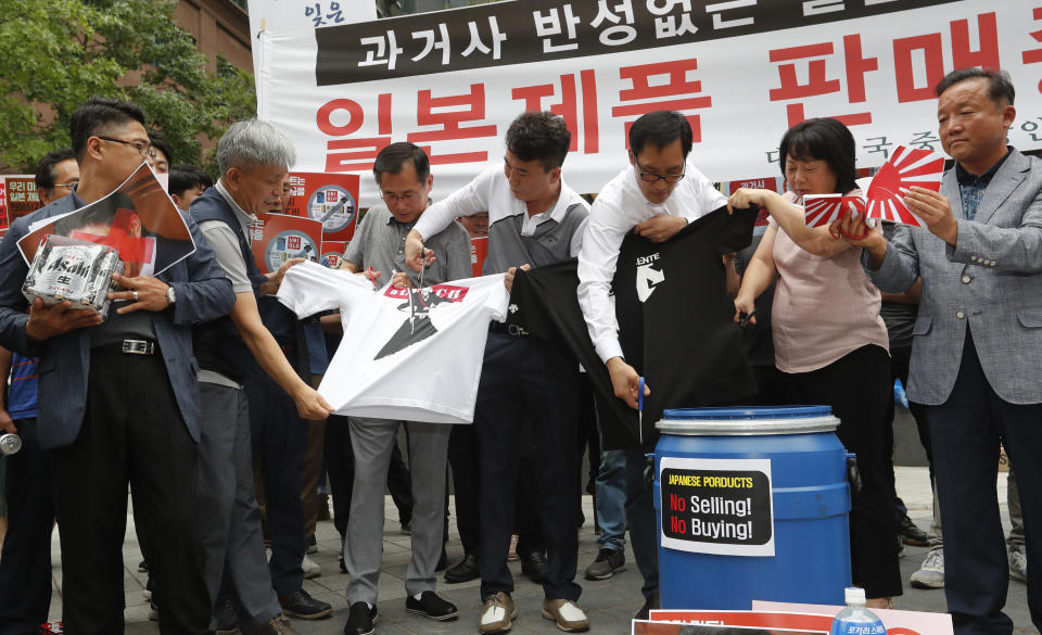 South Korean small and medium-sized business owners use scissors to cut t-shirts from Japanese brands during a rally calling for boycott of Japanese products in front of the Japanese embassy in Seoul, South Korea, Monday, July 15, 2019. South Korea and Japan last Friday, July 12, failed to immediately resolve their dispute over Japanese export restrictions that could hurt South Korean technology companies, as Seoul called for an investigation by the United Nations or another international body. The signs read: "Our supermarket does not sell Japanese products." (AP Photo/Ahn Young-joon)