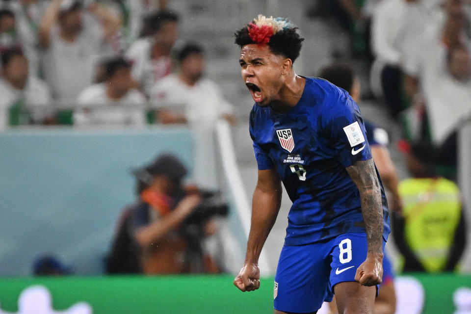 TOPSHOT - USA's midfielder #08 Weston McKennie celebrates his team's first goal scored by USA's forward #10 Christian Pulisic during the Qatar 2022 World Cup Group B football match between Iran and USA at the Al-Thumama Stadium in Doha on November 29, 2022. (Photo by Patrick T. Fallon / AFP) (Photo by PATRICK T. FALLON/AFP via Getty Images)