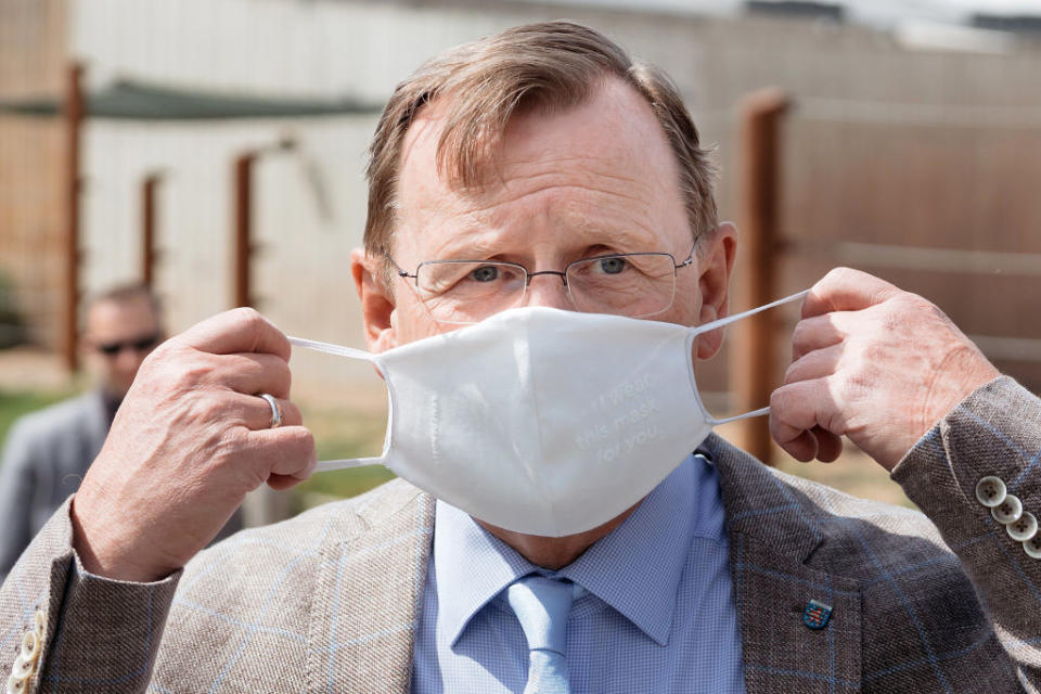 19 May 2020, Thuringia, Erfurt: Bodo Ramelow (left), Minister President of Thuringia, puts on a mouthguard at the media event at Zoopark Erfurt. Photo: Michael Reichel/dpa-Zentralbild/dpa (Photo by Michael Reichel/picture alliance via Getty Images)