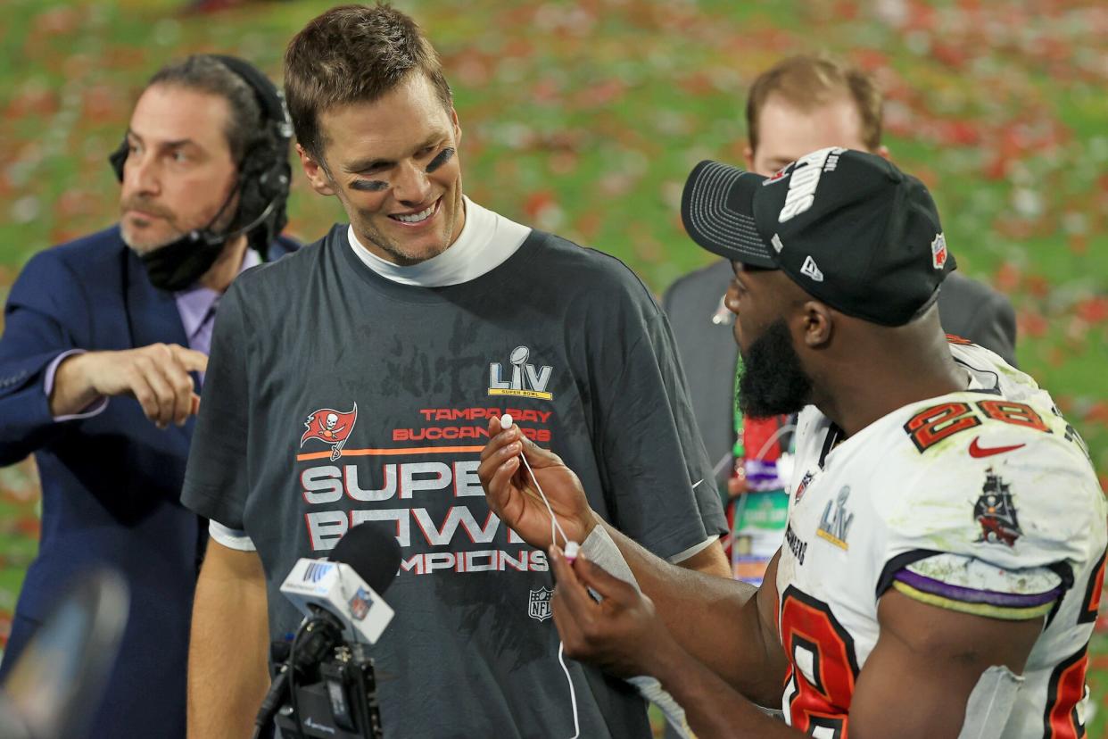 Tom Brady #12 of the Tampa Bay Buccaneers is interviewed with Leonard Fournette #28 after winning Super Bowl LV at Raymond James Stadium on February 07, 2021 in Tampa, Florida. The Buccaneers defeated the Chiefs 31-9.