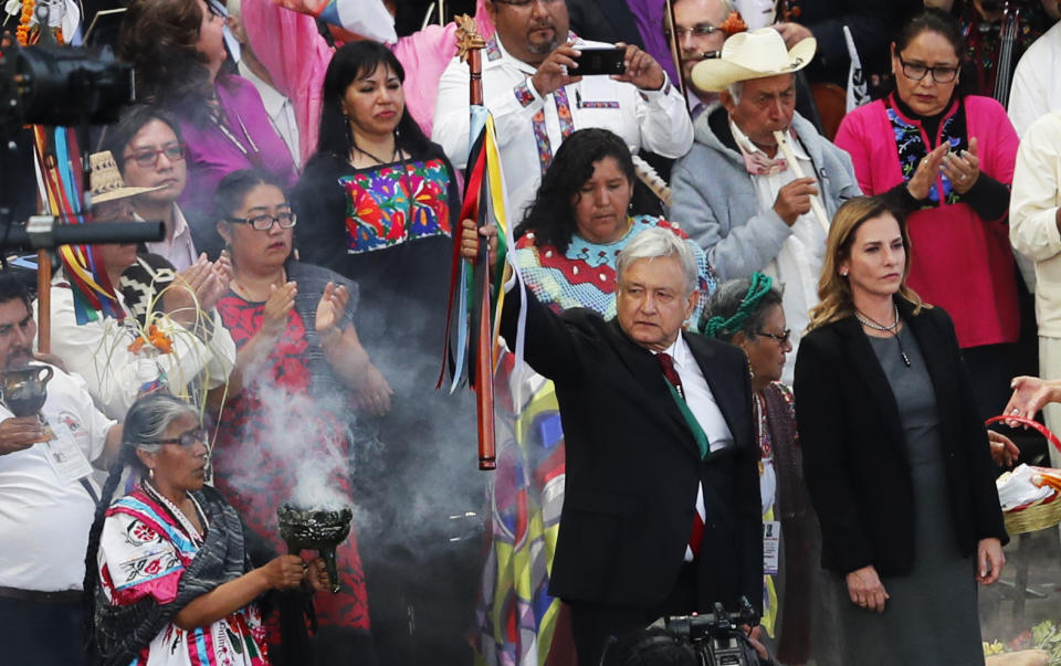 Mexico's new President Andres Manuel Lopez Obrador, center, participates in a traditional indigenous ceremony at the Zocalo, in Mexico City, Saturday, Dec. 1, 2018. Mexicans are getting more than just a new president Saturday. The inauguration of Lopez Obrador will mark a turning point in one of the world's most radical experiments in opening markets and privatization(AP Photo/Marco Ugarte)