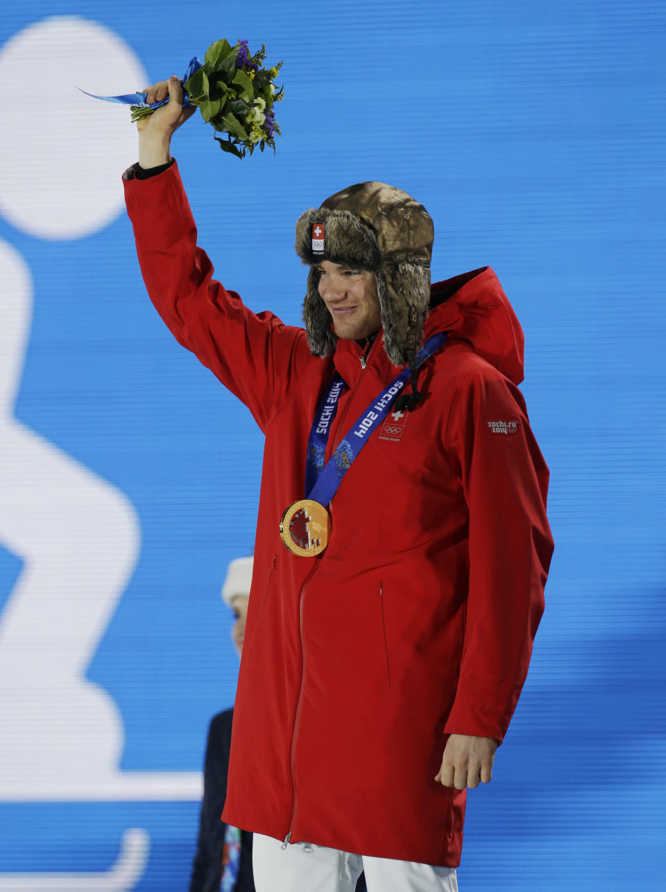 Men's cross-country 30k skiathlon gold medalist Dario Cologna of Switzerland smiles during the medals ceremony at the 2014 Winter Olympics, Sunday, Feb. 9, 2014, in Sochi, Russia. (AP Photo/Morry Gash)