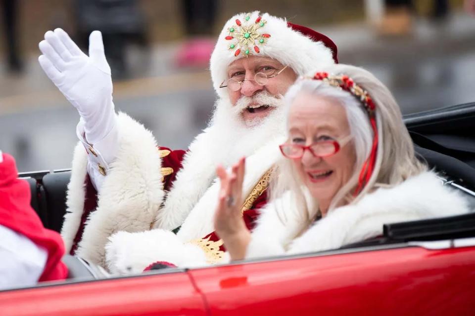 Santa and Mrs. Claus give hearty waves to the crowd.