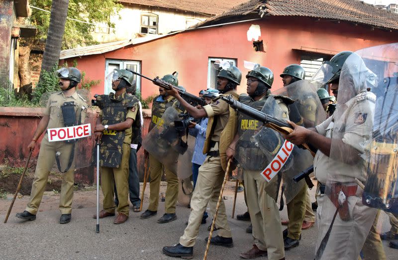 Policemen aim their guns during a protest against a new citizenship law, in Mangaluru