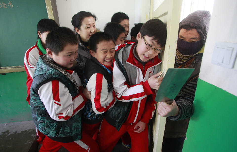 A teacher and her students try to shut a door against an intruder during an anti-violence exercise at a primary school in Jinan, Shandong province, December 18, 2012. The exercise was held four days after last Friday's knife attack at an primary school in Henan province, leaving more than 20 children and an elderly villager injured. Picture taken December 18, 2012. REUTERS/China Daily (CHINA - Tags: CRIME LAW EDUCATION) CHINA OUT. NO COMMERCIAL OR EDITORIAL SALES IN CHINA