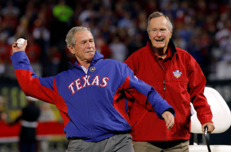 FILE PHOTO: Former U.S. President George H.W. Bush (R) watches as his son, former President George W. Bush, throws a ceremonial first pitch prior to the start of Game 4 of Major League Baseball's World Series between the San Francisco Giants and the Texas Rangers, in Arlington, Texas, October 31, 2010. REUTERS/Brian Snyder/File Photo