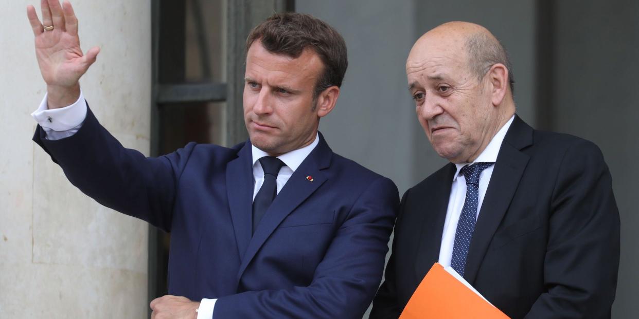 French President Emmanuel Macron (L) speaks with Foreign Affairs Minister Jean-Yves Le Drian on the doorsteps of the Elysee presidential palace after a guest's departure on June 17, 2019 in Paris.