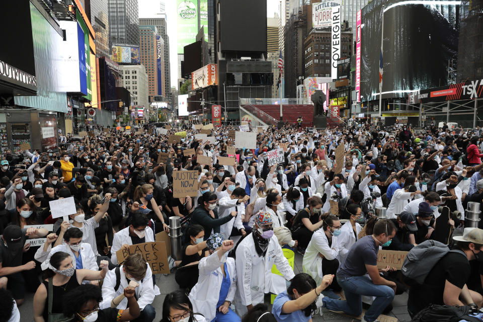 Protesters kneel in Times Square in New York, Tuesday, June 2, 2020. New York City extended an 8 p.m. curfew all week as officials struggled Tuesday to stanch destruction and growing complaints that the nation's biggest city was reeling out of control night-by-night. (AP Photo/Seth Wenig)