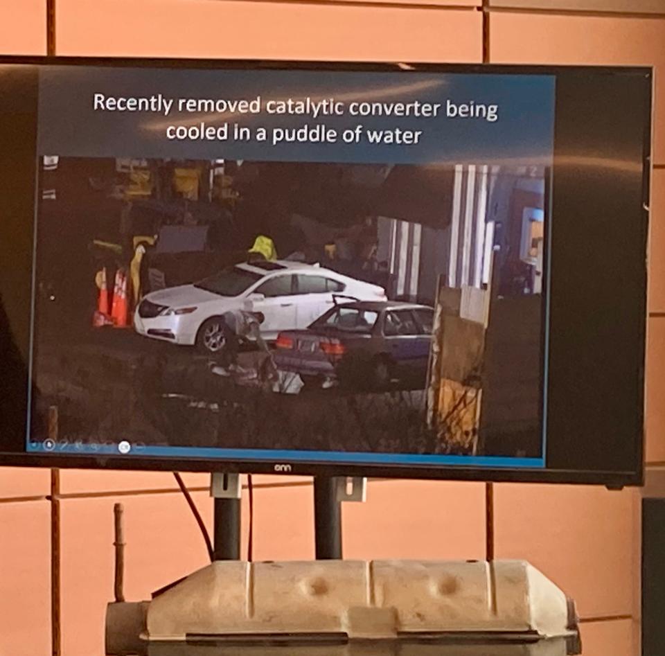 This slide from a presentation Tuesday shows a suspected catalytic converter thief attempting to cool the still-hot car part in a puddle of water before removing it.