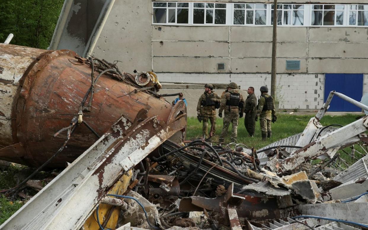 Police officers stand next to a television tower partially destroyed by a Russian missile in Kharkiv, Ukraine on April 22