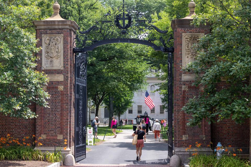 People walk through the gate on Harvard Yard at the Harvard University campus
