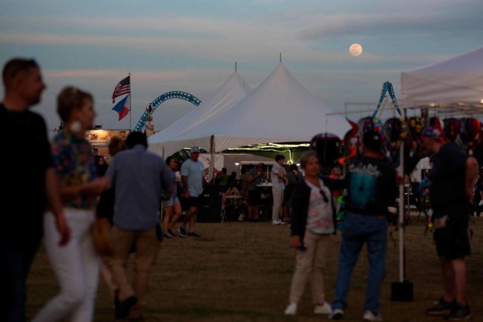 Festival attendees wander through food and merchant tents during the Gulf Coast Hot Air Balloon Festival at OWA in Foley, Alabama on Thursday, May 4, 2023.