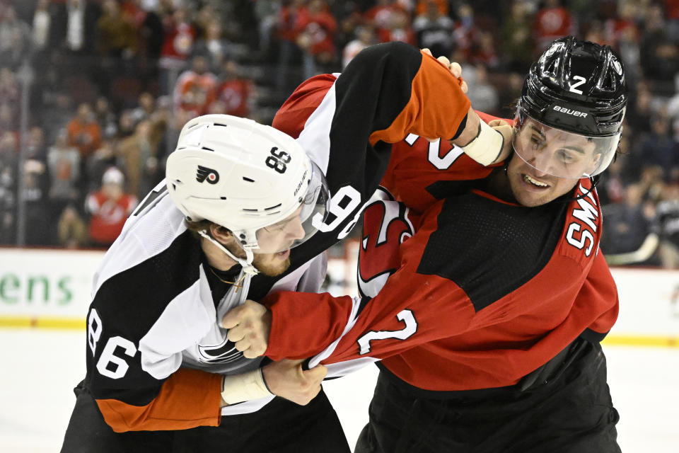 New Jersey Devils defenseman Brendan Smith (2) fights with Philadelphia Flyers left wing Joel Farabee (86) during the second period of an NHL hockey game Thursday, Dec. 15, 2022, in Newark, N.J. (AP Photo/Bill Kostroun)