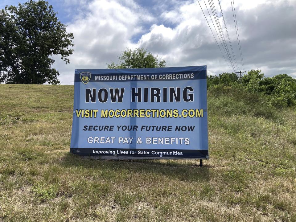 A "Now Hiring" sign is shown at the entrance to a Missouri Department of Corrections prison facility, Thursday, July 13, 2023, in Fulton, Mo. Nearly 1-in-4 positions were vacant late last year at the Department of Corrections. But vacancies have been declining since a pay raise was implemented this spring. (AP Photo/David A. Lieb)