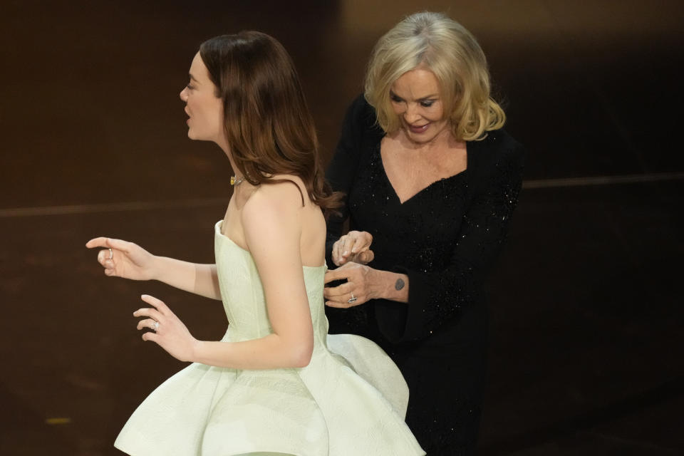 Jessica Lange, derecha, le ajusta el vestido a Emma Stone en los Oscar el domingo 10 de marzo de 2024, en el Teatro Dolby en Los Ángeles. (Foto AP/Chris Pizzello)