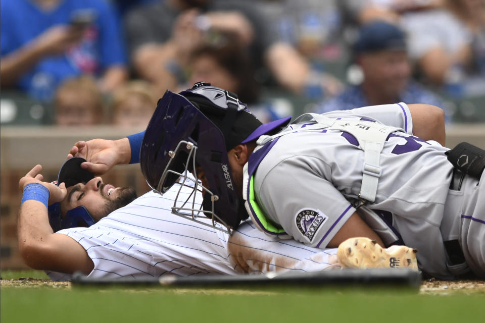 Chicago Cubs' Alfonso Rivas, left, is tagged out at home plate by Colorado Rockies catcher Elias Diaz, right, during the fifth inning of a baseball game, Saturday, Sept. 17, 2022, in Chicago. (AP Photo/Paul Beaty)