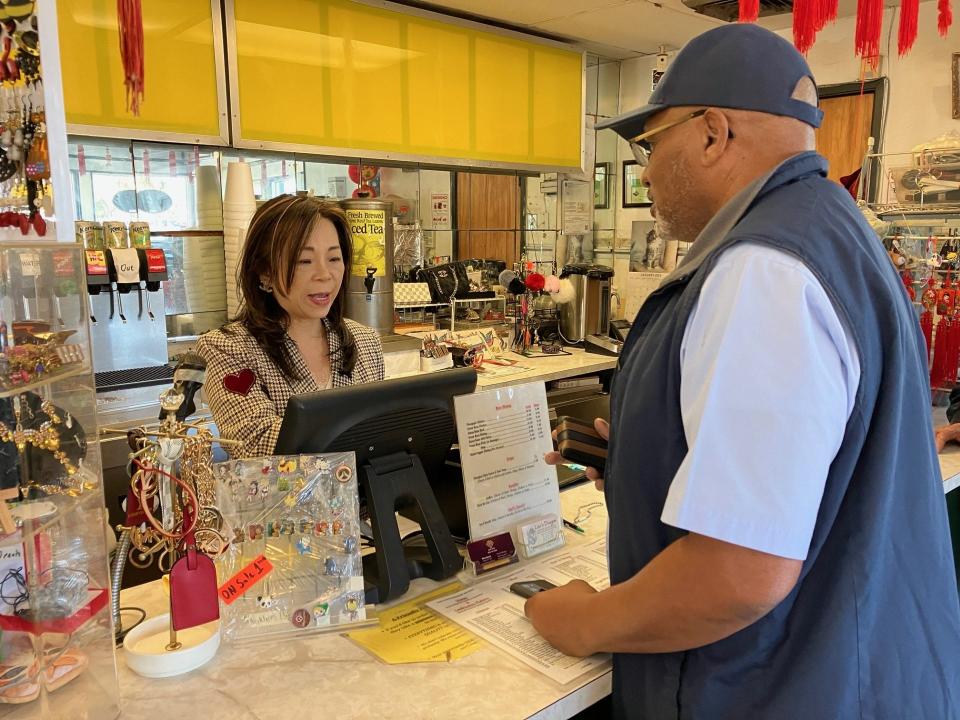 Lily Lee of family-owned Lee's Dragon takes an order from longtime customer Ralph Brown on Wednesday, Jan. 31, 2024, the restaurant's final day of business.