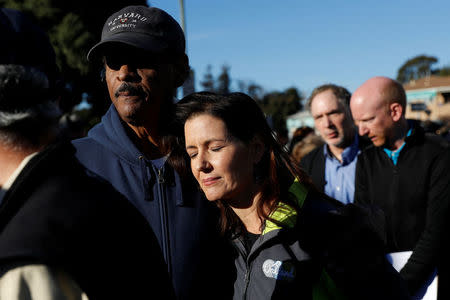 Oakland City Council Member Larry Reid (L) embraces Mayor Libby Schaaf after a new conference at the scene of a fire in the Fruitvale district of Oakland, California, U.S. December 3, 2016. REUTERS/Stephen Lam