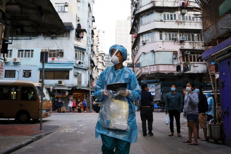A medical worker in a protective suit walks near the residential area, in Hong Kong