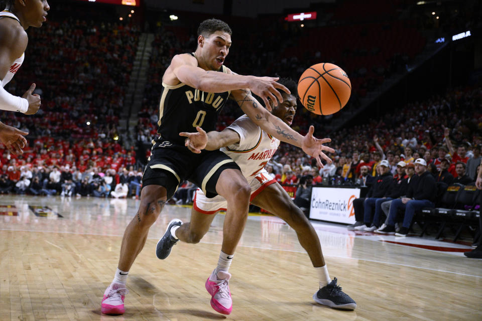 Purdue forward Mason Gillis (0) and Maryland guard Jahari Long, right, reach for the ball during the first half of an NCAA college basketball game Tuesday, Jan. 2, 2024, in College Park, Md. (AP Photo/Nick Wass)