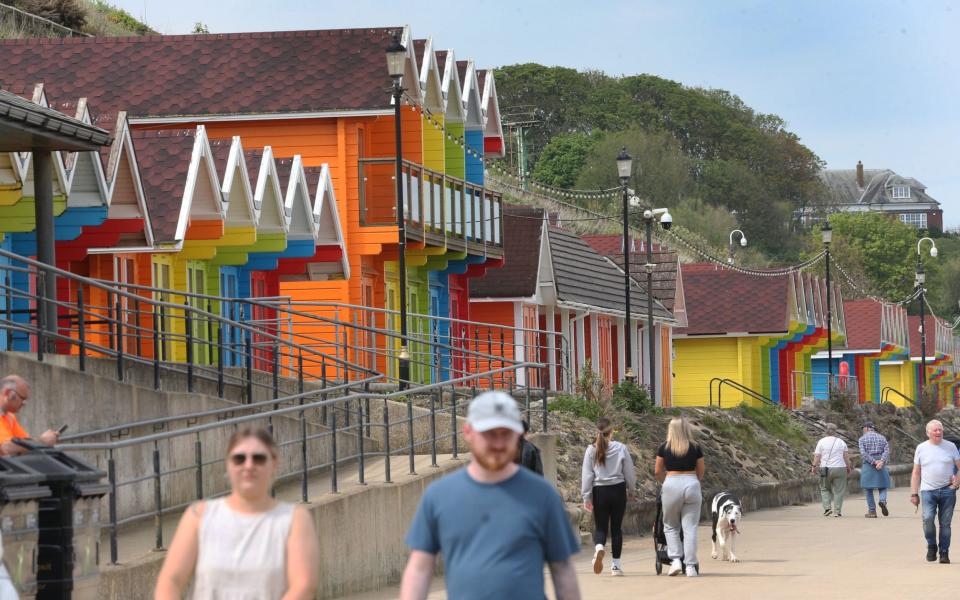 There are colorful huts along the beach