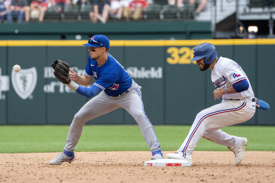 Texas Rangers' Isiah Kiner-Falefa is safe as Toronto Blue Jays third baseman Cavan Biggio waits for the late throw on an attempted fielder's choice during the eighth inning of a baseball game Monday, April 5, 2021, in Arlington, Texas. (AP Photo/Jeffrey McWhorter)