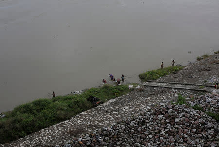 People gather on the banks of the Brahmaputra river in Jogighopa, in the northeastern state of Assam, India August 2, 2018. REUTERS/Adnan Abidi