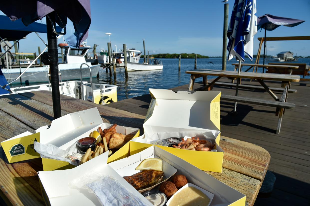 Clockwise from front: Blackened grouper, conch fritters and cheese grits; Mahi Mahi, fried shrimp, lemon, cocktail sauce, conch fritters, french fries and coleslaw; and peel & eat shrimp – all at the Star Fish Company Dockside Restaurant, 12306 46th Ave. W. in the village of Cortez.